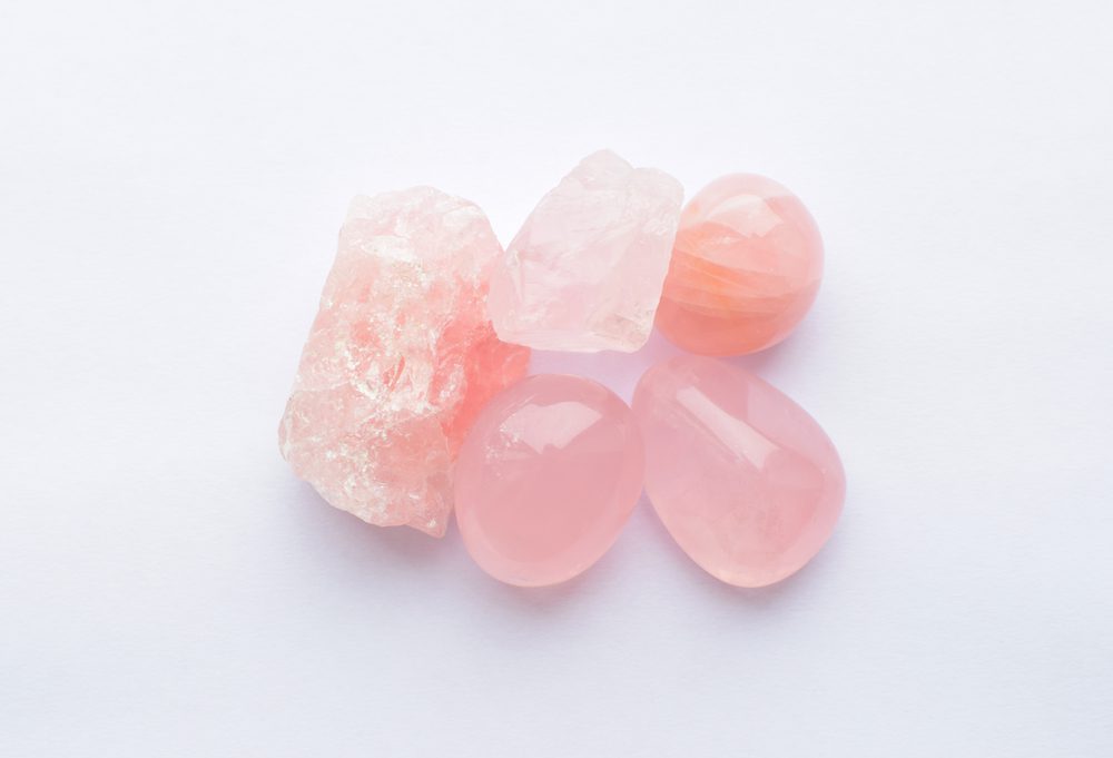 Crystals of rose quartz on a white background. Beautiful semi-precious stones