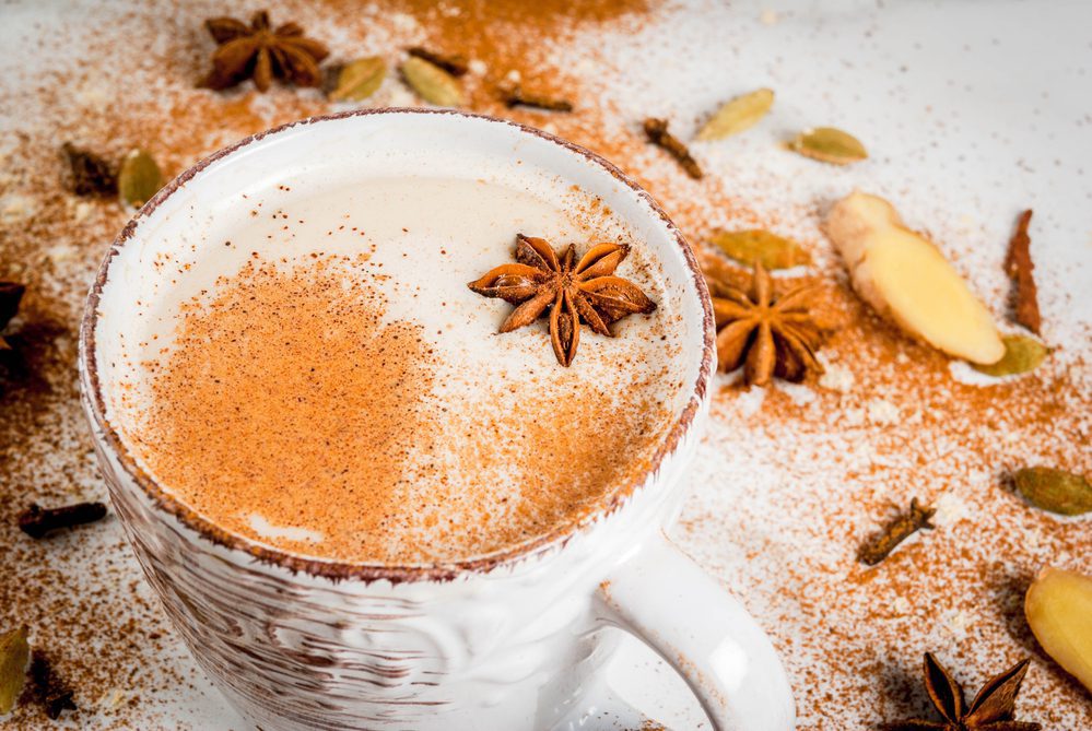 Traditional indian masala tea with spices - cinnamon, cardamom, anise, white background. 