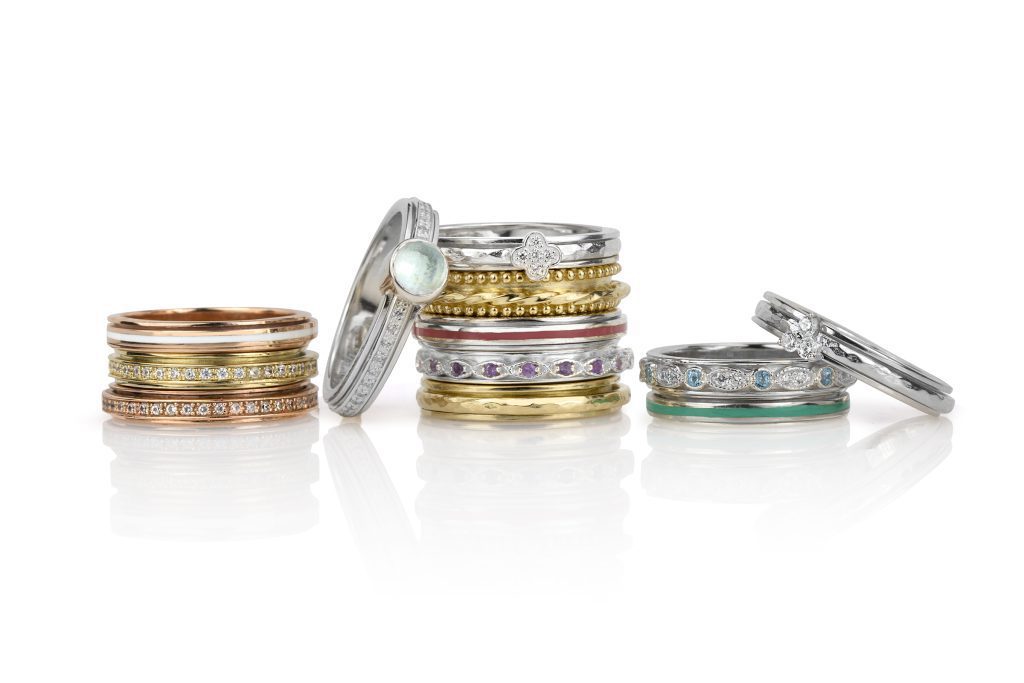 Stackable spinning anxiety rings featuring diamonds, sapphires, and opal gemstones