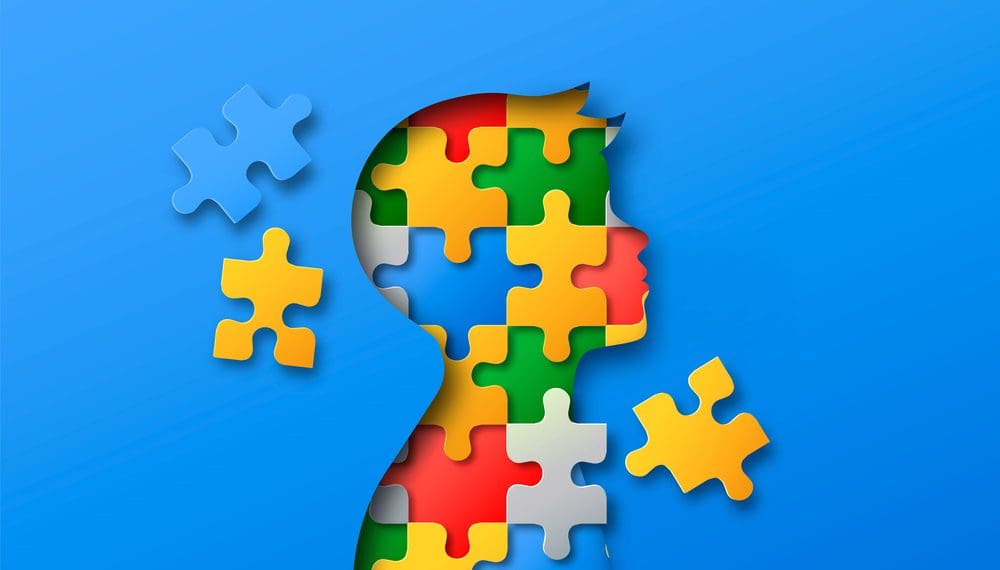 Little boy head profile silhouette made of colorful paper cut puzzle pieces. Children education or psychology illustration concept in realistic 3d papercut style to represent Applied Behavior Analysis Therapy