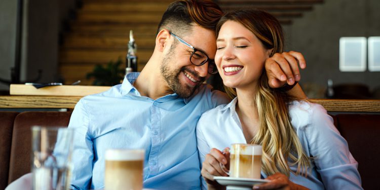 Romantic loving young couple dating as a single parent, drinking coffee, having a date in the cafe.