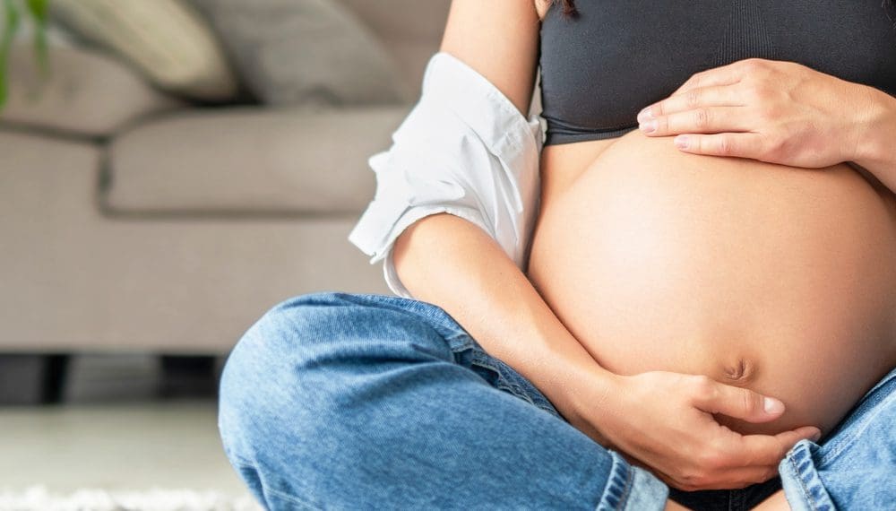 Pregnant woman holding a fidget ring, showcasing steps to manage anxiety during pregnancy with tools from Anxiety Gone.