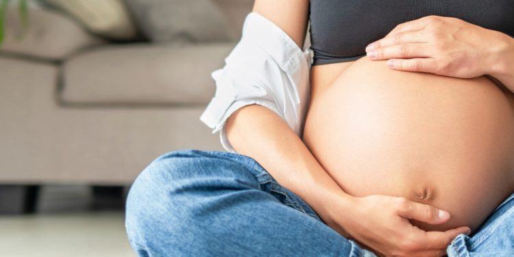 Pregnant woman holding a fidget ring, showcasing steps to manage anxiety during pregnancy with tools from Anxiety Gone.