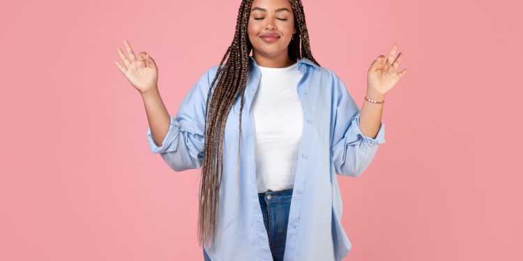 Woman practicing deep breathing exercises with a fidget ring, using mindfulness techniques to calm an anxiety attack.