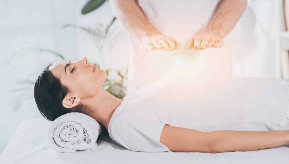 A person holding a worry stone while practicing grounding techniques for anxiety, symbolizing the connection between trauma and anxiety relief through self-care items and relaxation gifts like fidget rings,