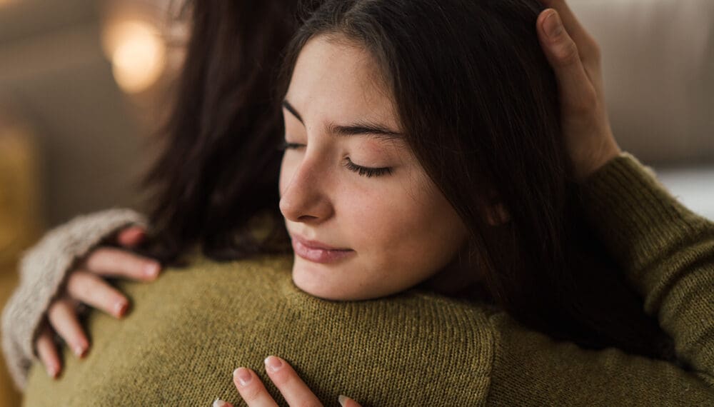 Woman holding a fidget ring and journal as part of her self-care routine for managing anxiety and mental health.