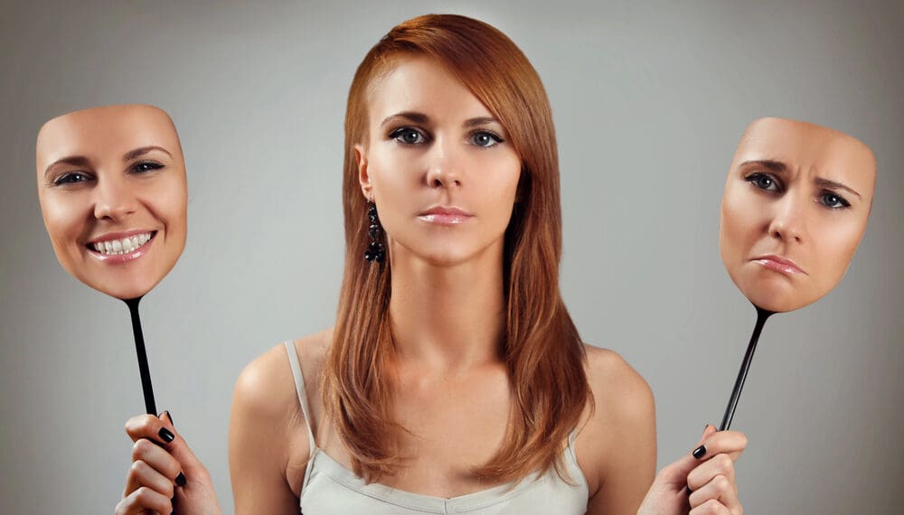 Woman removing a mask to reveal her true self, representing masking mental health, anxiety masking, ADHD masking, and the emotional journey of unmasking personality and identity.
