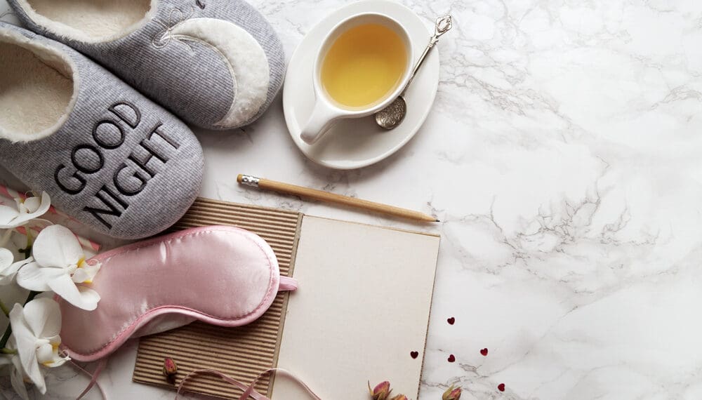 Calming night routines setup with journal, herbal tea, candle, and fidget ring to support relaxing routines, sleep routine, and how to relax at night
