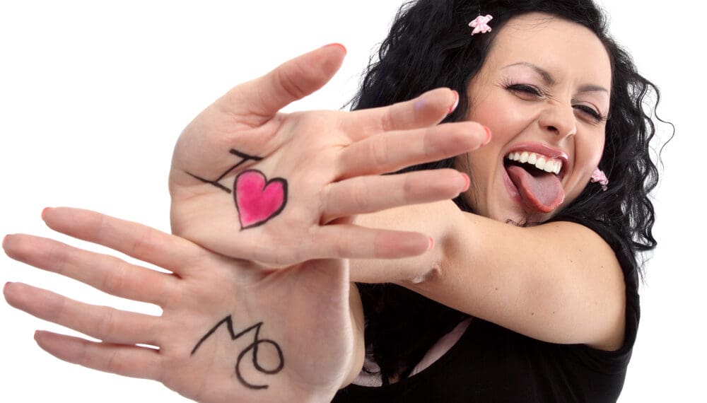 Woman showing self love wearing a fidget ring on a cozy couch, practising self-awareness for anxiety relief and emotional burnout recovery.