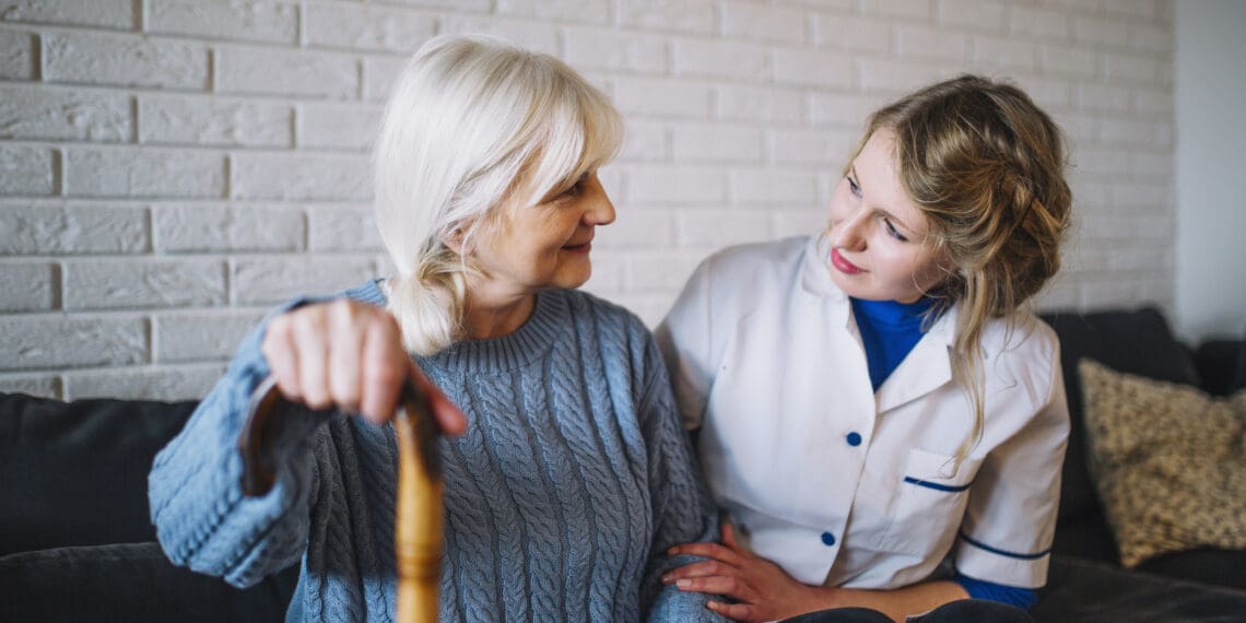 Senior woman smiling with adult child in a comfortable retirement home setting